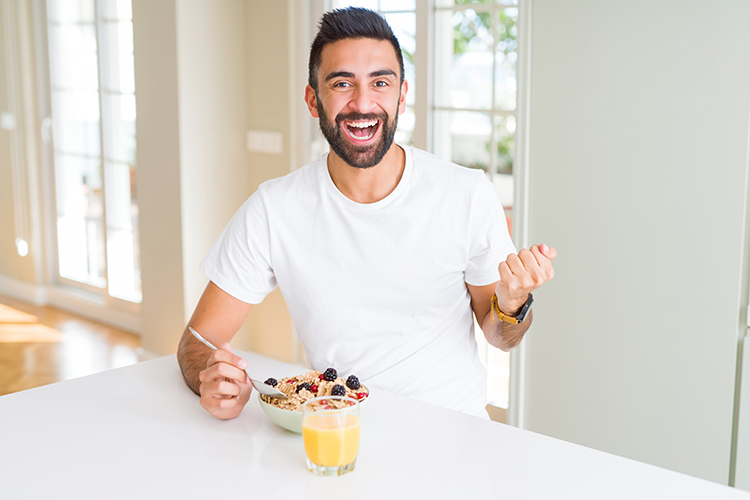 Man Eating a Healthy Breakfast in the Morning, Feeling Highly Motivated