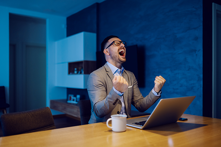 Overjoyed, stylish, handsome, unshaven businessman in a suit celebrating success late at night