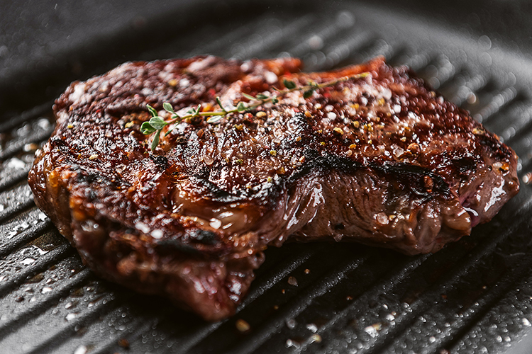 Steak from a fresh piece of marbled beef, fried in a pan