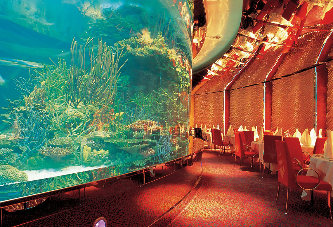 El Mahara 餐厅以玻璃窗墙后面的景色而著称。 在他们身后……海鳗和其他奇怪的鱼在游泳。 “El Mahara”位于水下深处，您只能乘坐专门为此类访问提供的迷你潜艇才能到达这里。