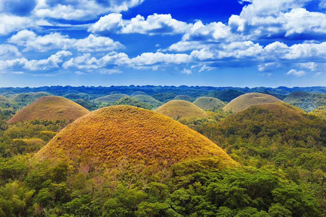 Шоколадні пагорби – дивовижне геологічне утворення невідомого походження у філіппінській провінції Бохоль. Тут на площі 50 квадратних кілометрів розташована величезна кількість пагорбів. Вони вкриті зеленою травою, яка під час сухого сезону змінює свій колір на коричневий – звідси і походить назва пагорбів.