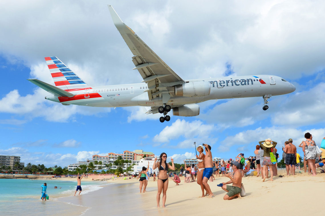 Maho Beach is located on the Caribbean island of Sint Maarten (part of the Netherlands), in its southern part. This extreme beach is famous due to the fact that the airport runway adjoins it closely, so that landing and taking off planes fly only 10–20 meters above the heads of vacationers.