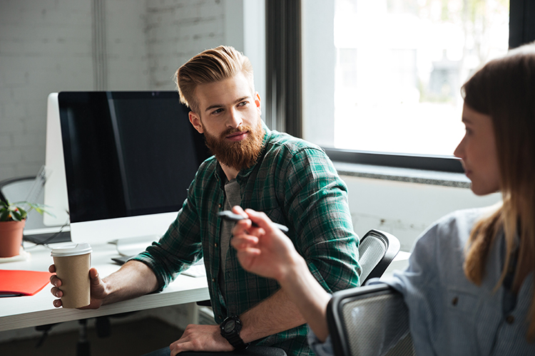 Man in office attentively listening to his colleague