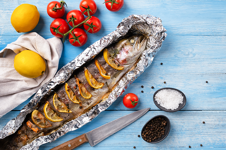 Trout baked in aluminum foil with lemon